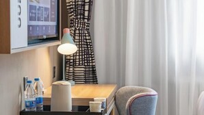 A hotel room with a desk, a chair, a lamp, a television, and a window with curtains. - Homeinn Hotel (Weifang Xinhua Road Shengli East Street City Government Plaza) (Weifang)
