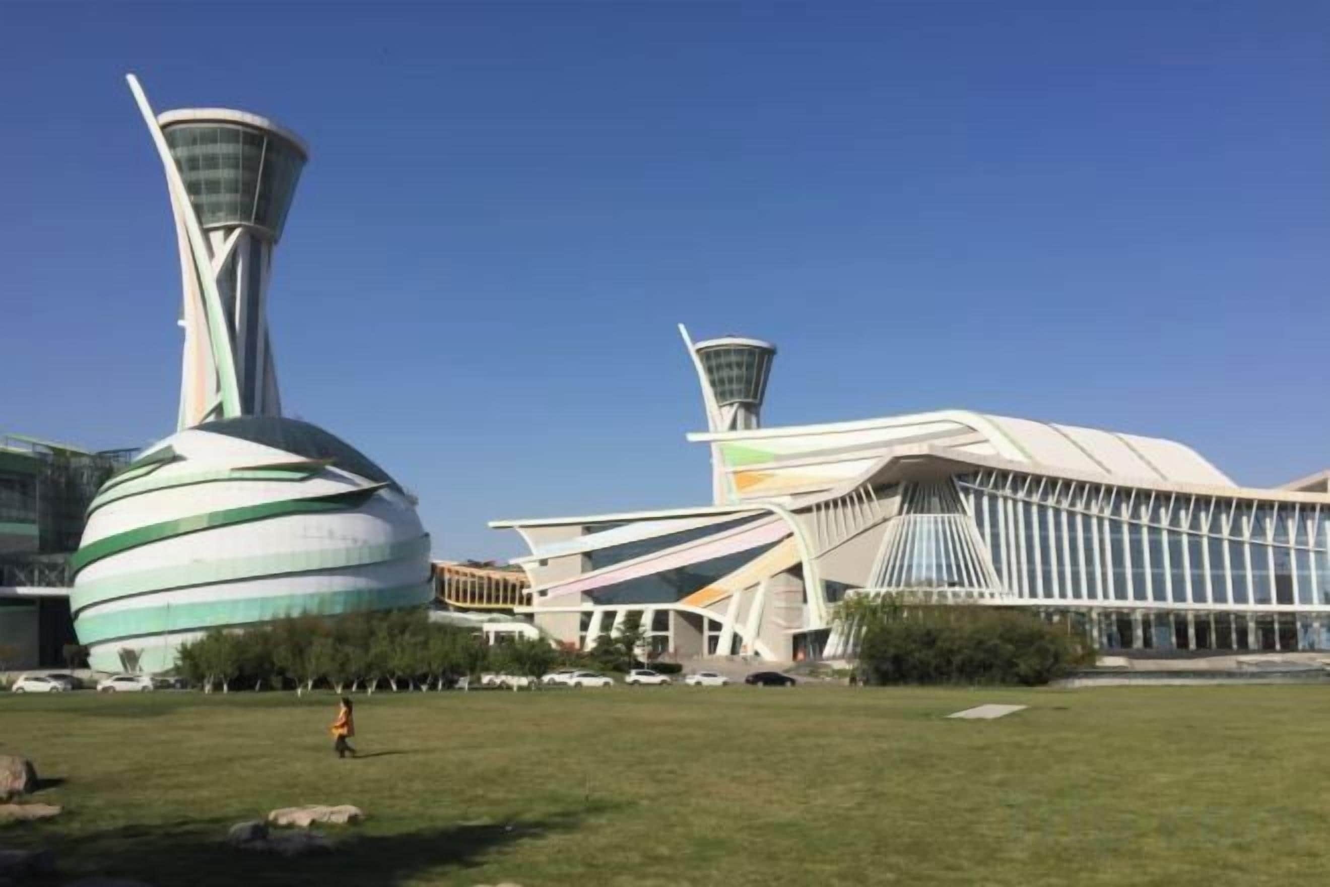 Un edificio moderno con un diseño arquitectónico único, que presenta una estructura grande y curva, así como una torre.