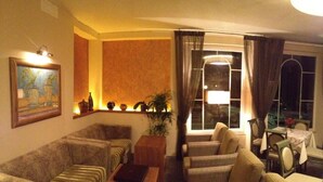 A living room with a sofa, armchairs, a coffee table, and a dining area with a table and chairs.
