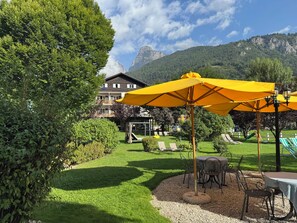 Un espace extérieur bien aménagé, doté d’une terrasse, de sièges et offrant une vue sur une montagne.