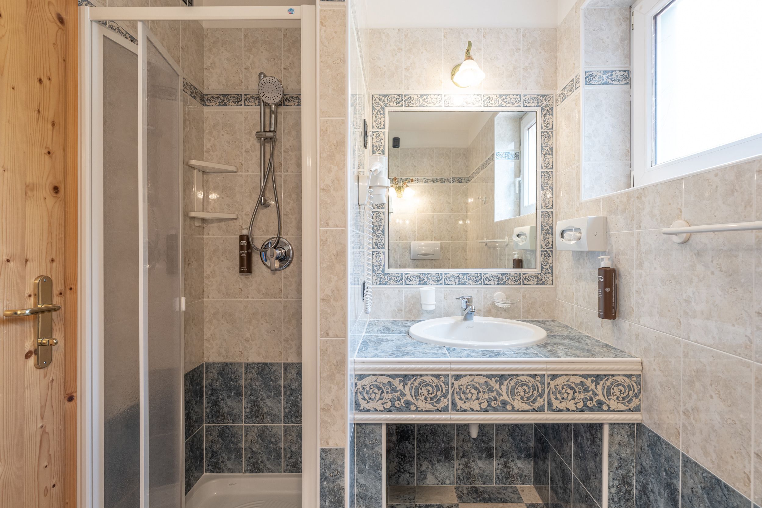 A bathroom with a shower, a sink, and a mirror.