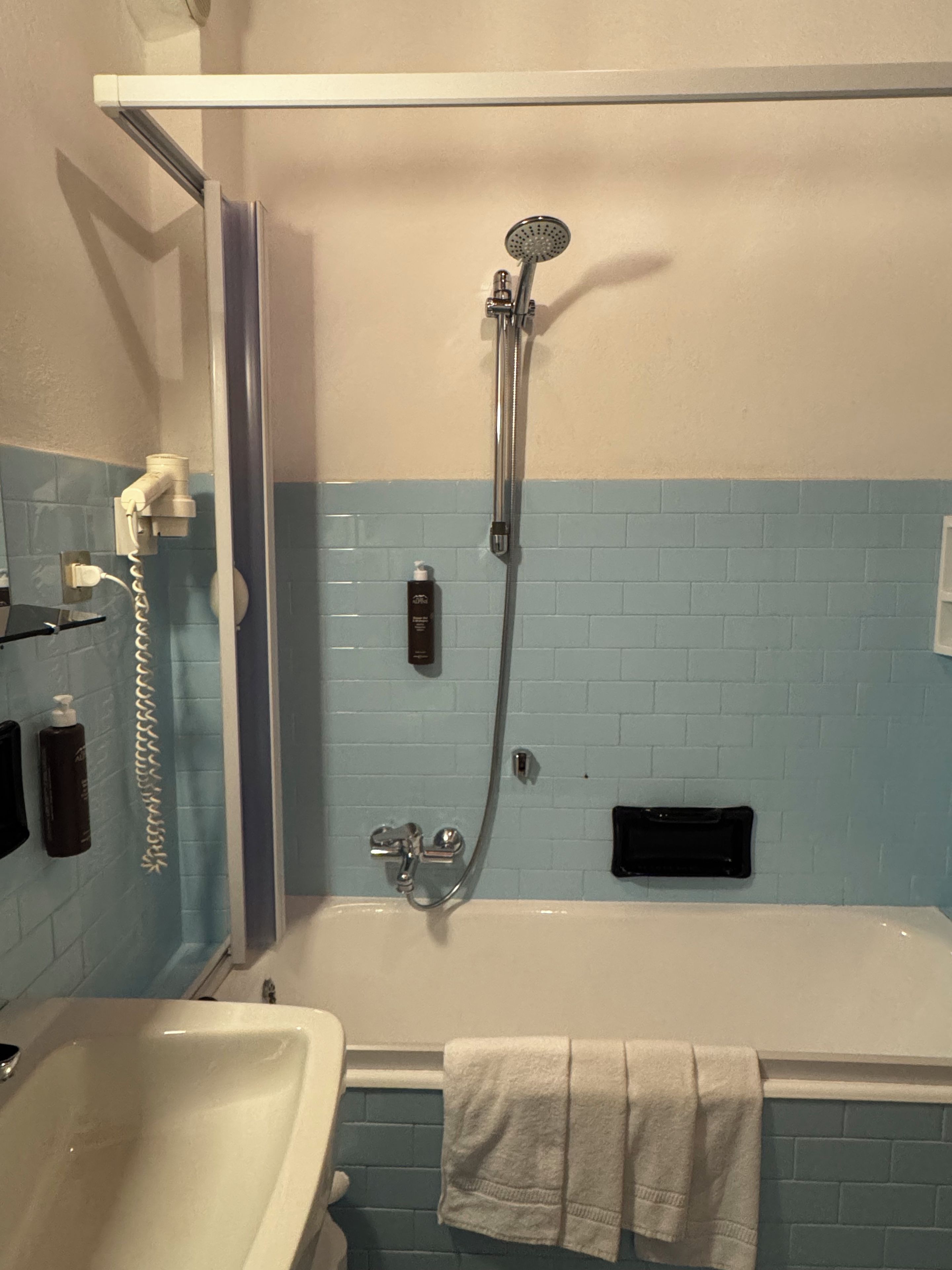 A bathroom with a bathtub, a shower, and a sink.