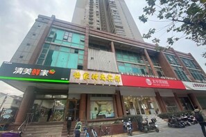 A multi-story building with commercial establishments on the ground floor, including a restaurant and a service center. - Yijia Business Hotel (Shanghai)