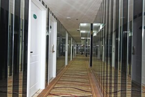 A corridor with glass doors, carpeted flooring, and a ceiling with recessed lighting. - Yijia Business Hotel (Shanghai)