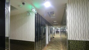 A corridor with patterned walls, a carpeted floor, and a glass partition. - Yijia Business Hotel (Shanghai)