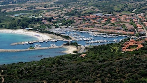 Un pueblo costero con un puerto deportivo, playa y edificios residenciales.