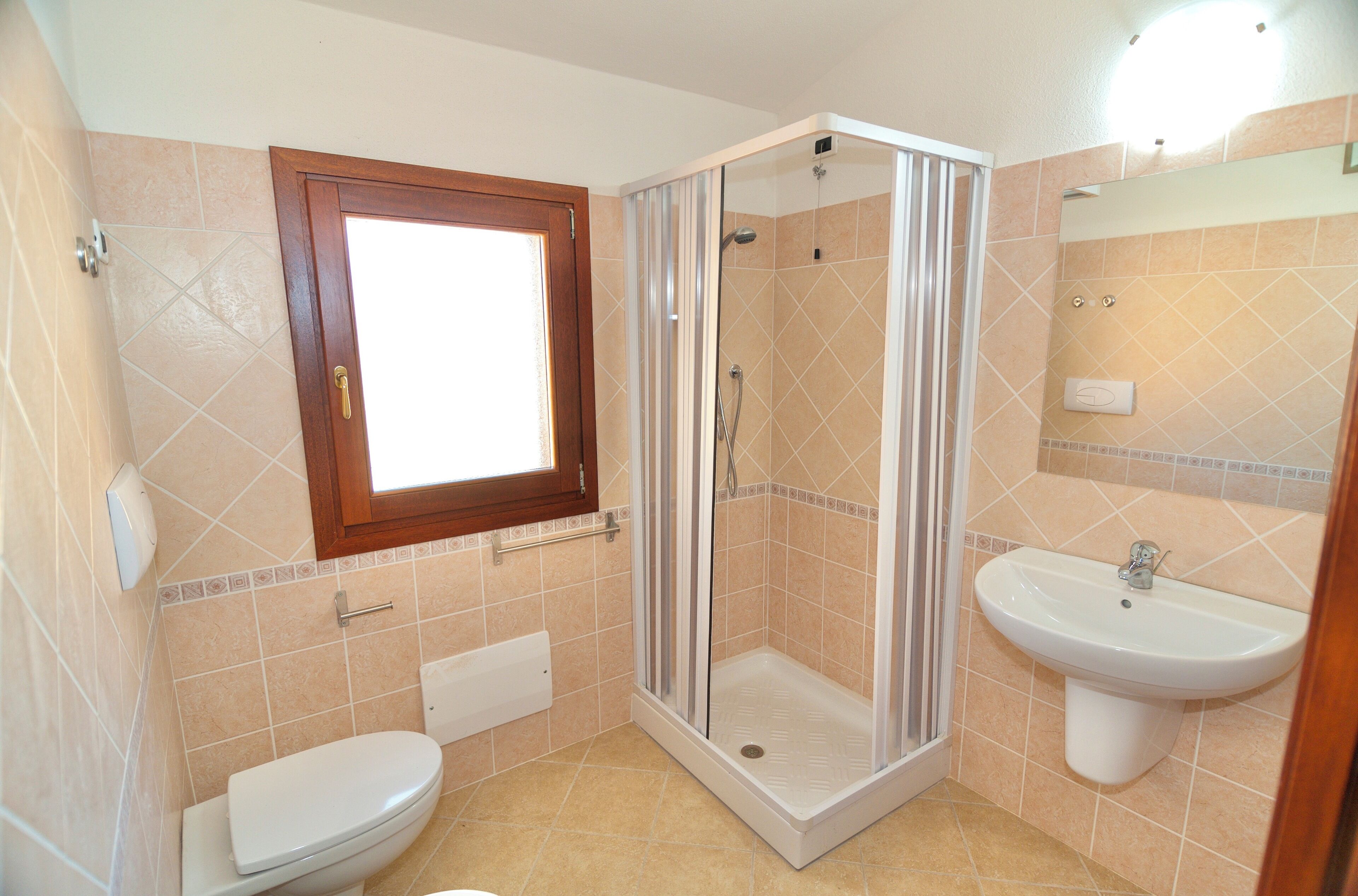 A bathroom with a toilet, a shower enclosure, and a sink.