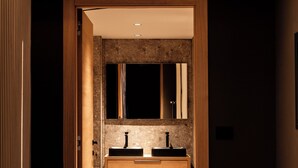 Une salle de bain moderne avec un meuble-lavabo en bois, deux vasques et un grand miroir.
