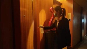 A person opening a wooden door in a hallway. - Pingliang Rongting Hotel (Pingliang)