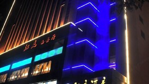 A building with illuminated signage and vertical light strips. - Pingliang Rongting Hotel (Pingliang)