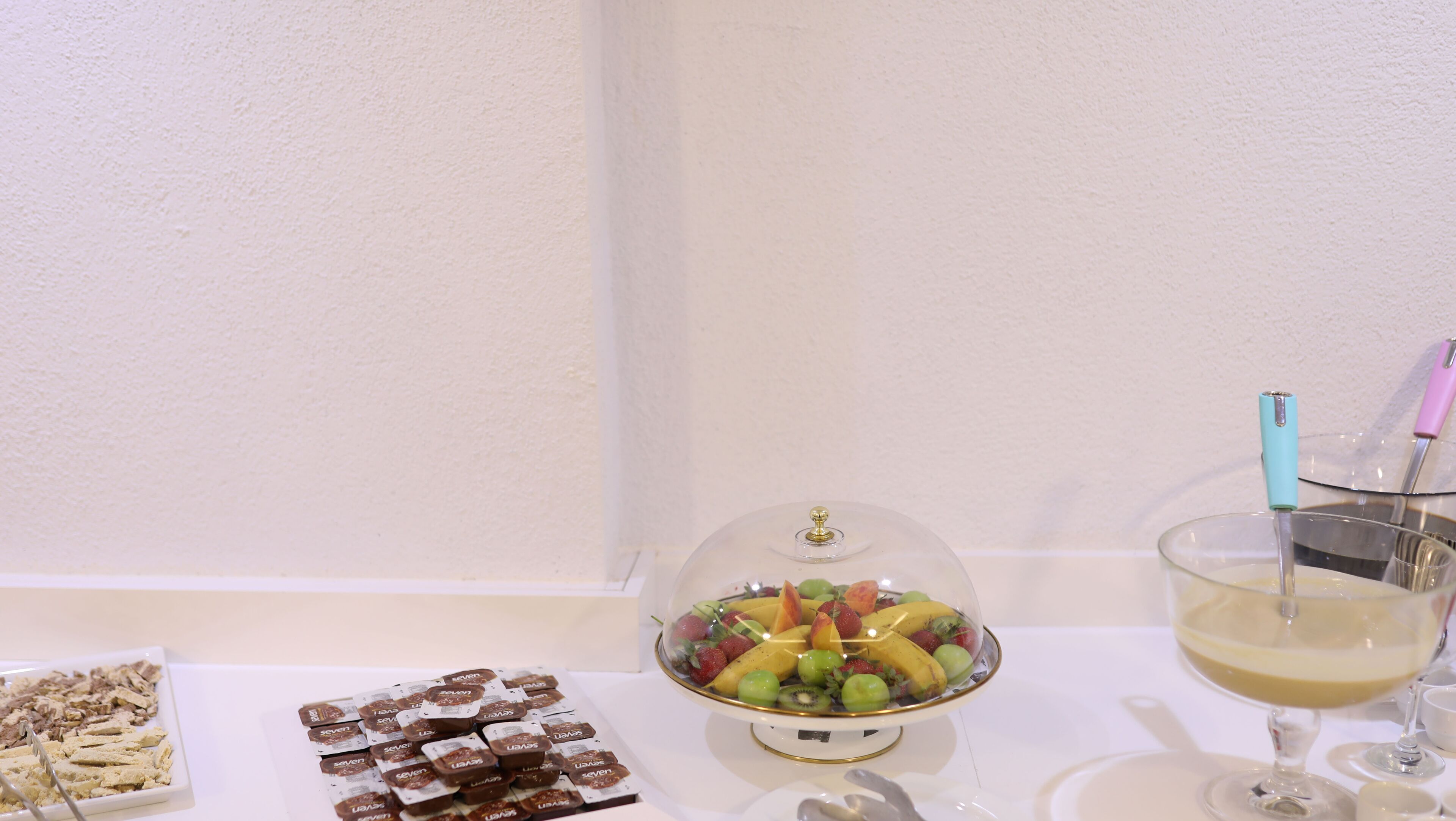 Et dessertbord med diverse kager og et fad med frugt.