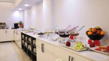 Una mesa de buffet con diversos alimentos y bebidas.