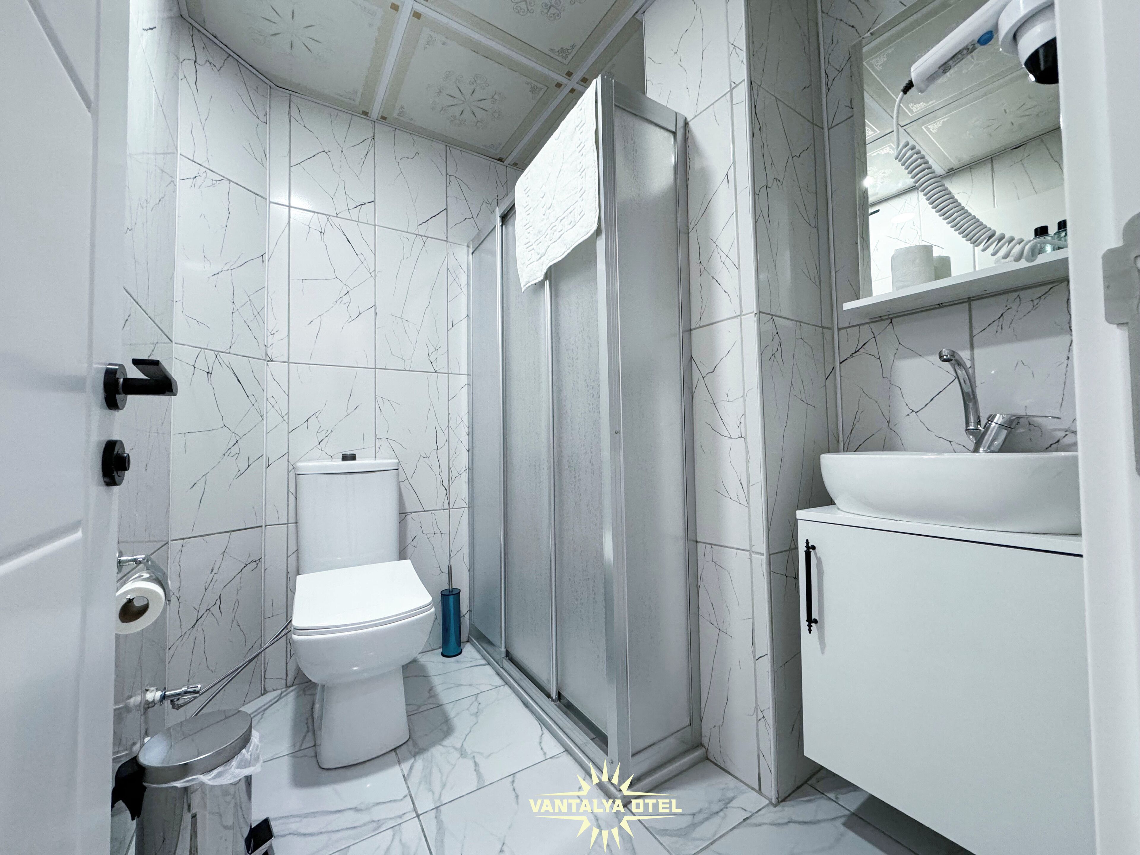 Un baño moderno con inodoro, ducha y lavamanos.