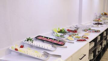 Una mesa de buffet con diversos alimentos y utensilios.