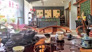 A traditional tea set on a table with a wooden tray, a clock, and a decorative vase. - Danxia Shanyang Yuancun Inn (core scenic spot) (Renhua)