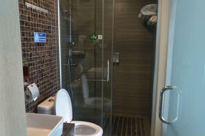 A bathroom with a toilet, a glass shower enclosure, and a towel rack. - Danxia Shanyang Yuancun Inn (core scenic spot) (Renhua)