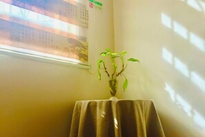 A room with a table, a plant, and a calendar on the wall. - Danxia Shanyang Yuancun Inn (core scenic spot) (Renhua)