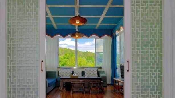 A room with a wooden floor, a dining table with chairs, a sofa, and a television. - Danxia Shanyang Yuancun Inn (core scenic spot) (Renhua)