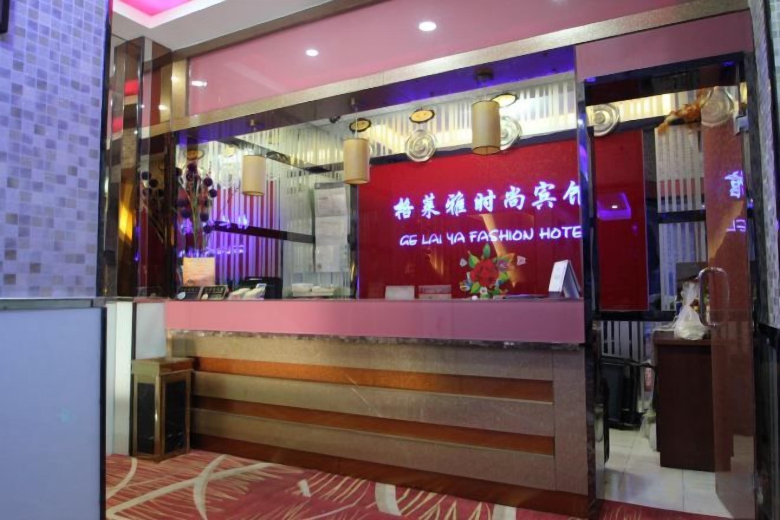 A hotel reception area with a red and purple color scheme, a reception desk, and a sign in a foreign language.