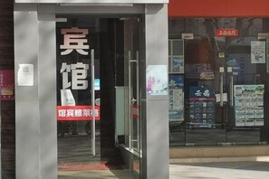 A hotel entrance with a glass door, a signboard, and a red banner. - Ge Lai Ya Hotel (Shanghai)