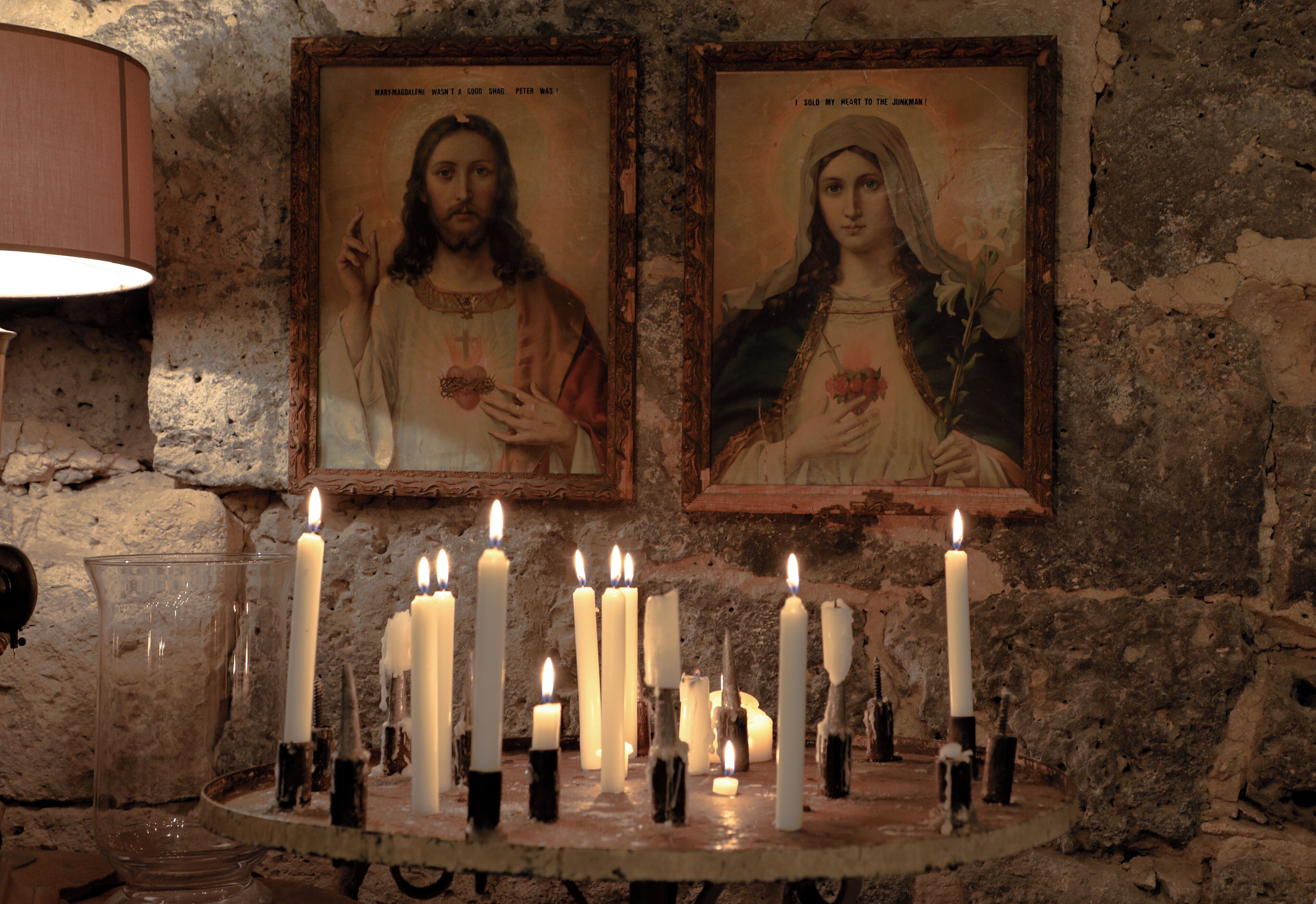 A religious icon with multiple candles in front of it.