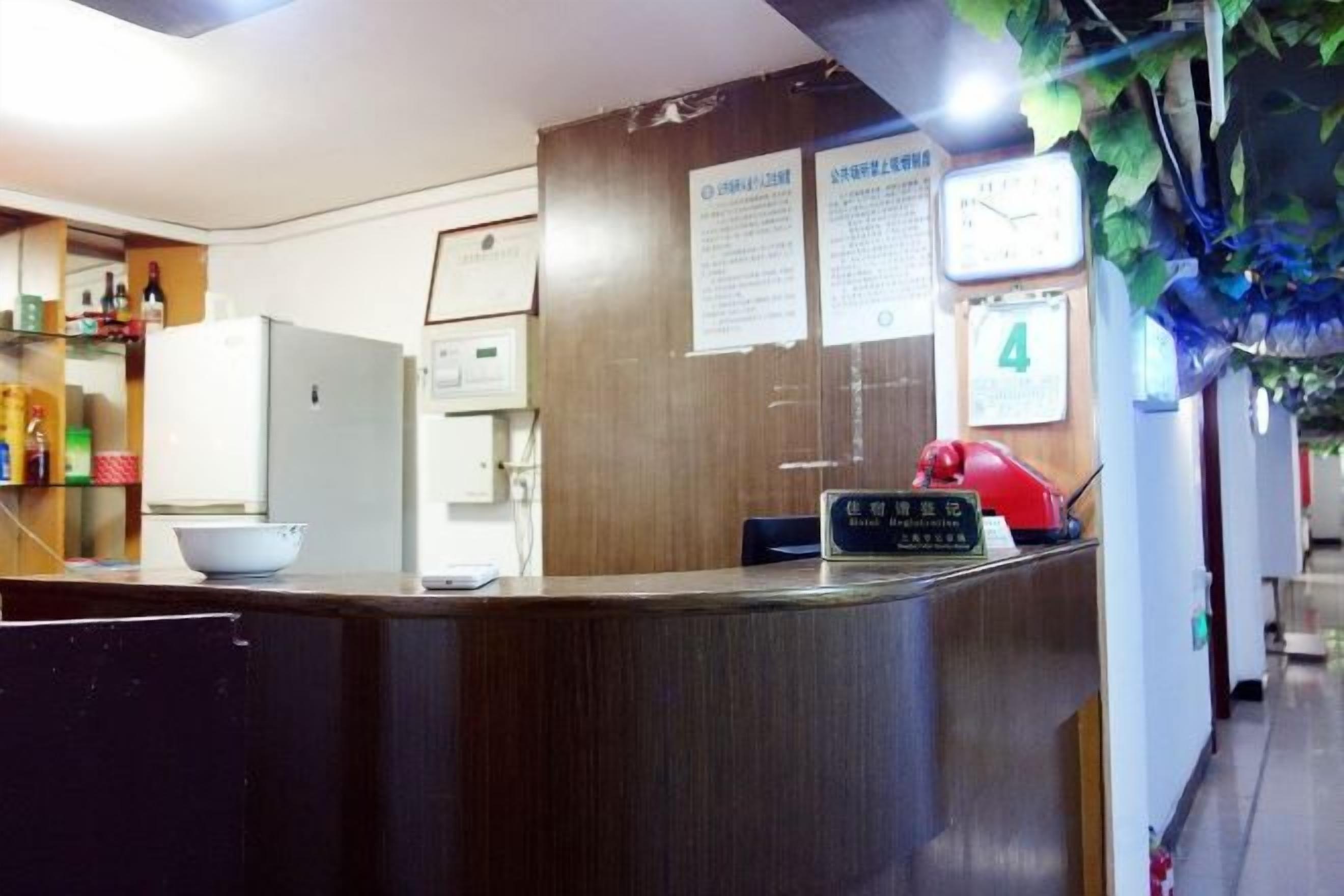 A reception area with a wooden counter, a clock, and a notice board.