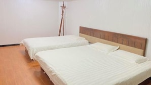 A room with two single beds, wooden headboards, and a floor lamp. - Huike Hostel (Shanghai)