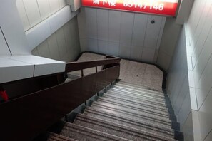 Eine Treppe mit Handlauf und einem roten Schild darüber.