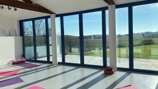 A spacious room with large windows, yoga mats, and a wooden ceiling. - Relaxation and Well-being break near Bordeaux | Yoga & Swimming pool (Chatenet)