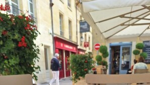 An outdoor café with a table set for a meal, including a cup of coffee, a pastry, and a plate of chocolates. - Relaxation and Well-being break near Bordeaux | Yoga & Swimming pool (Chatenet)