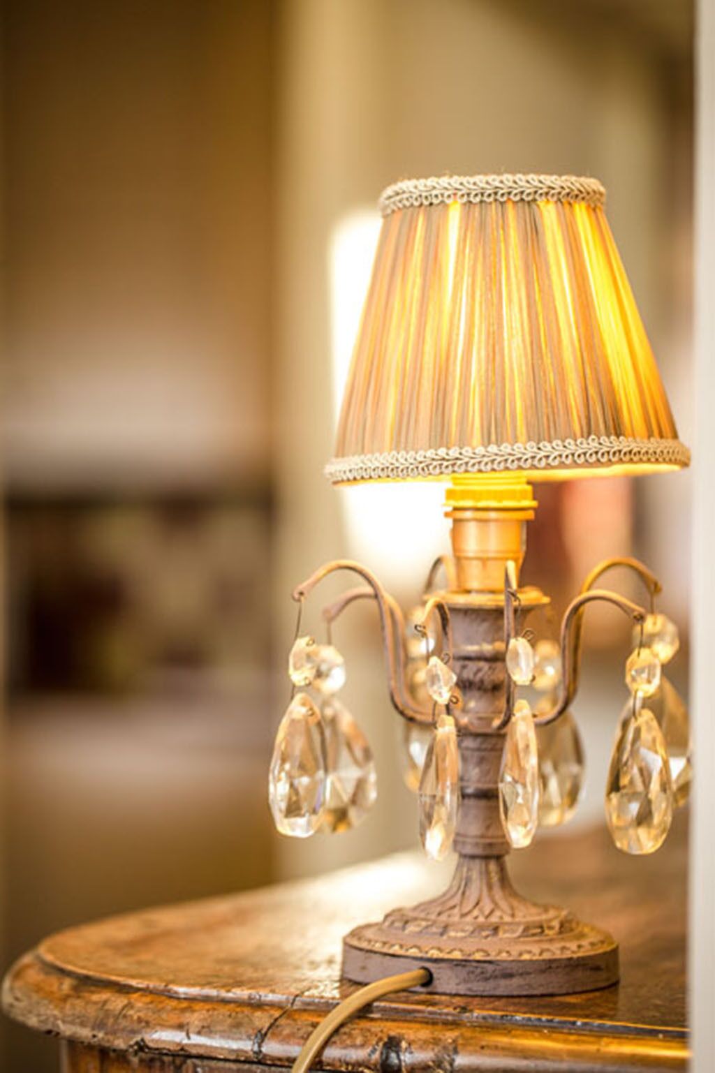 A vintage-style table lamp with a decorative base and a lampshade with a pleated design.