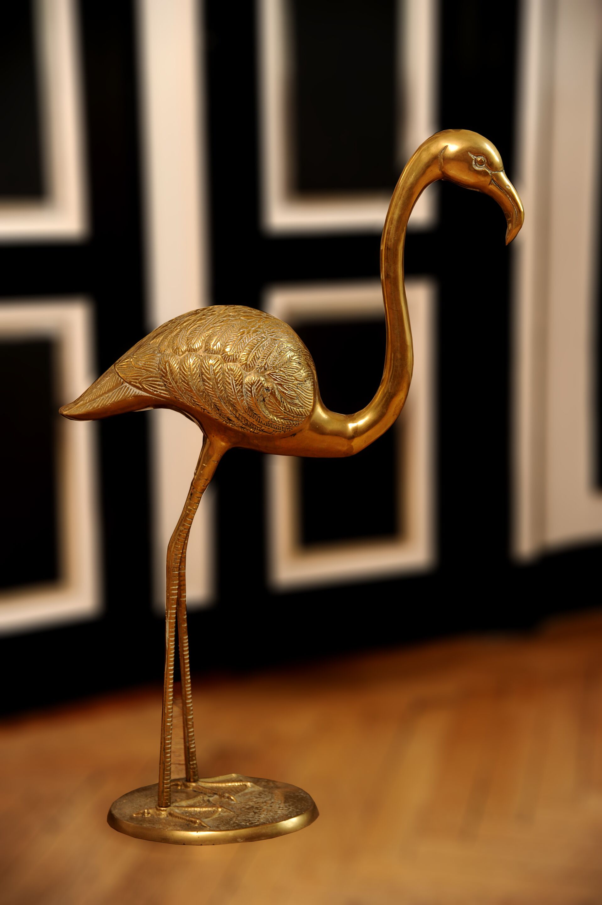 Uma estátua dourada de flamingo em um pedestal.