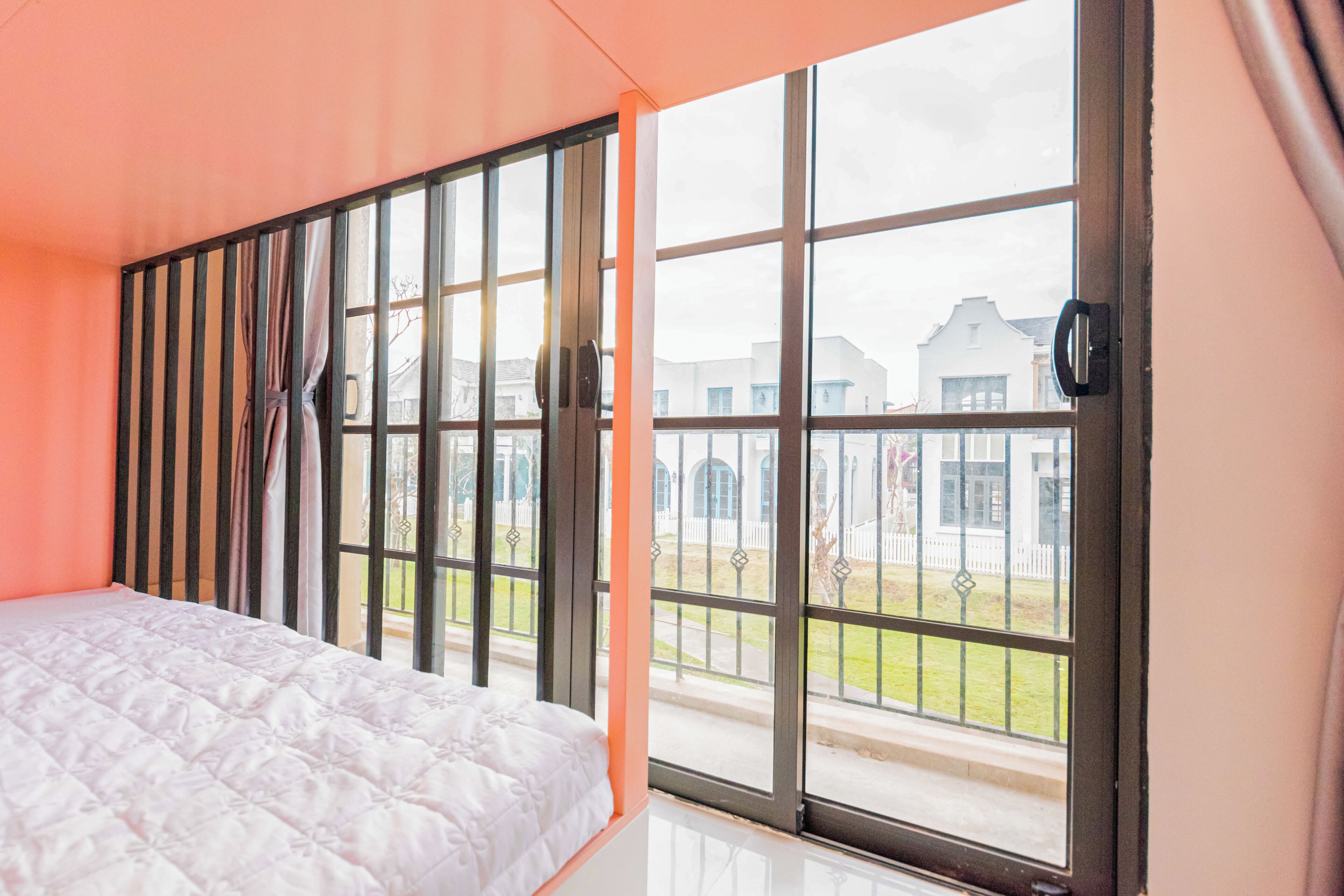 Un dormitorio con un ventanal grande, una cama y vistas al exterior.