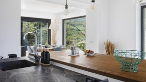 Una cocina moderna con encimera de madera, un fregadero y vistas a zonas verdes.