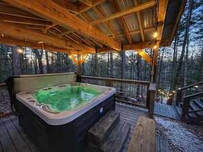 A hot tub on a wooden deck with a forest backdrop. - The Lookout | Secluded A-Frame | Hot Tub | Games (Campton)