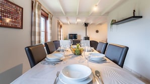 A dining area with a table set for four, a television in the background, and a fireplace. - Lovely apartment in villa for 6 people with WIFI and TV (Bruges)