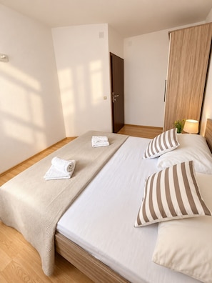A hotel room with a bed, a bedside table with a lamp, and a wardrobe.