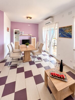 A dining area with a checkered floor, a wooden table, and chairs.