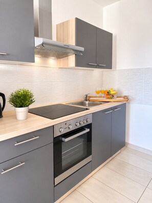 A modern kitchen with a built-in oven, a stovetop, and a sink.