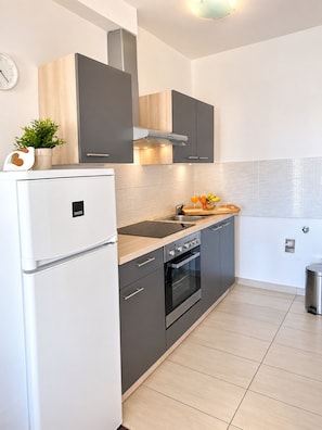 Una cocina moderna con refrigerador, horno y lavamanos.