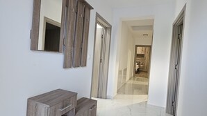 A hallway with a wooden vanity, a large mirror, and a marble floor. - Villa Pauliana (Povljana)