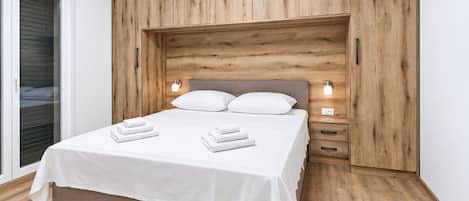 Un dormitorio con cama, mesitas de noche y cabecero de madera.
