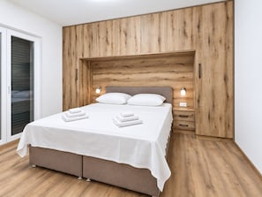 A bedroom with a bed, bedside tables, and a wooden headboard.