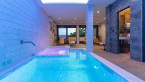 A modern indoor swimming pool with a skylight, a seating area with a view, and a spa room. - Villa Maiorum with indoor heated pool (Povljana)