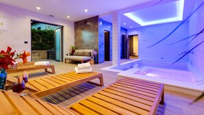 A modern spa area with wooden loungers, a large bathtub, and a glass-enclosed entrance. - Villa Maiorum with indoor heated pool (Povljana)
