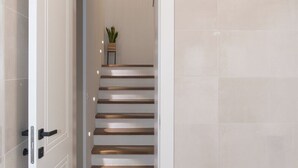 A modern interior with a staircase leading to a landing. - Beautiful Villa Aria (Zadar)