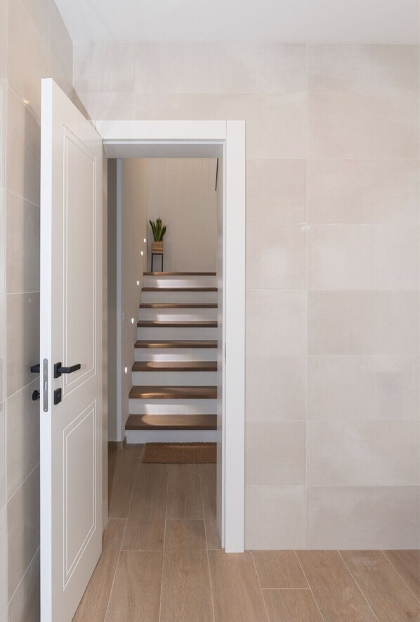 A modern interior with a staircase leading to a landing.