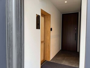 A hallway with a wooden door labeled "Reception" and a dark wooden door. - GOKAN KOTOHIRA (Kotohira)