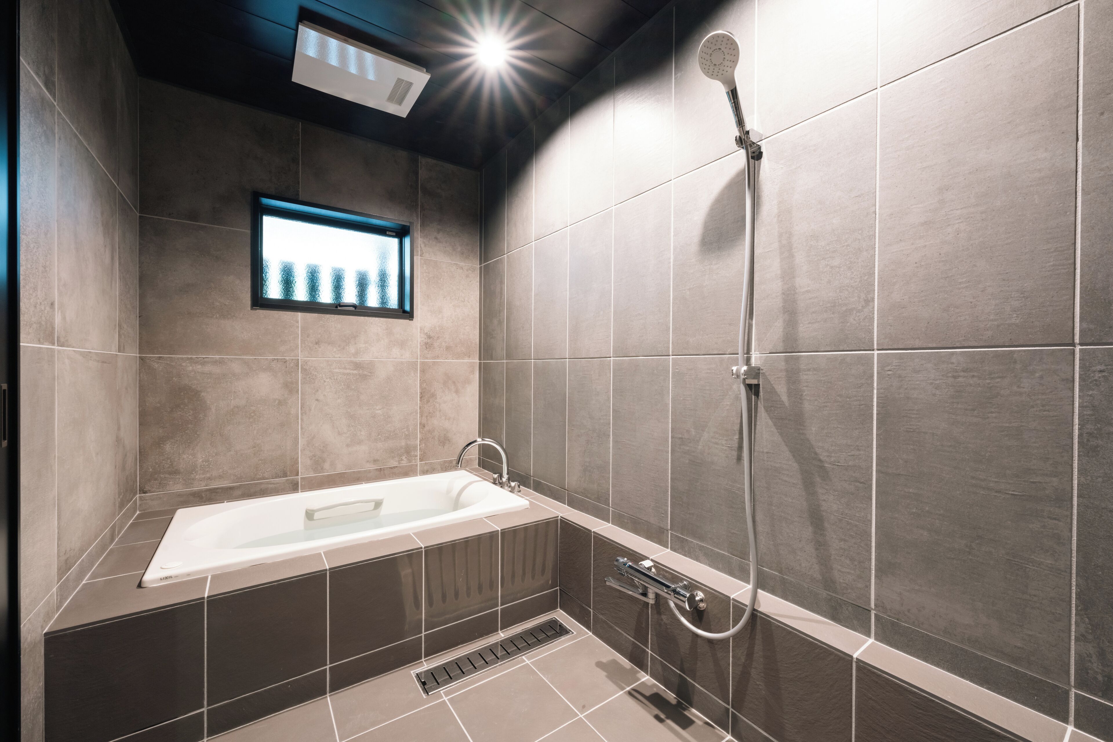 Un baño moderno con bañera, ducha y ventana.
