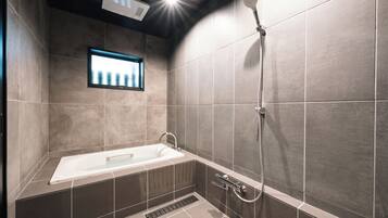 Un baño moderno con bañera, ducha y ventana.